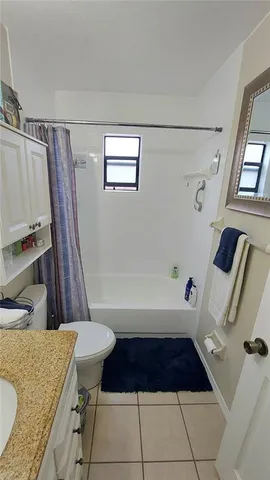 a bathroom with a granite countertop sink a toilet a bathtub and a shower