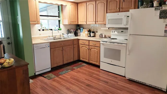 a kitchen with a white cabinets sink and white appliances