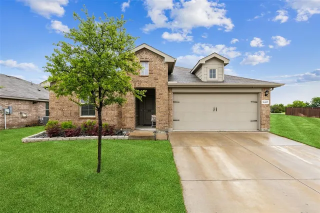 a view of a house with a backyard and garage