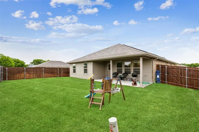 a view of a house with a backyard and porch