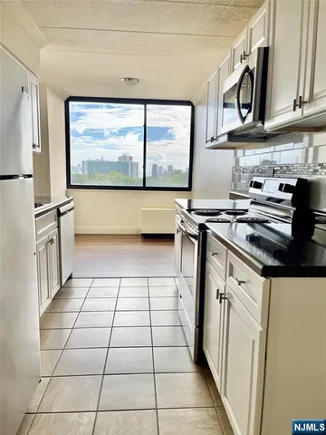 a kitchen with stainless steel appliances a stove a sink and a refrigerator