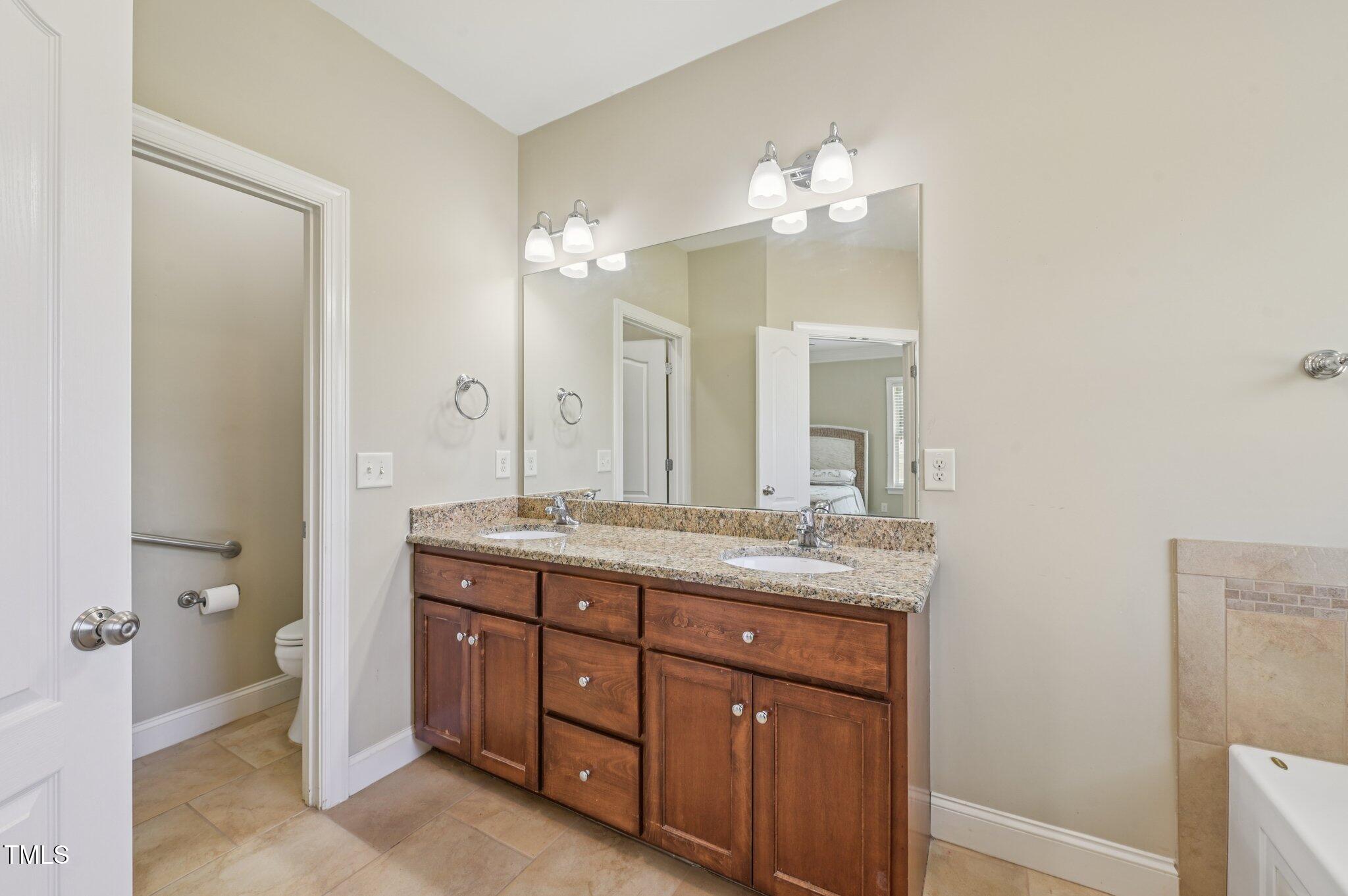 75 Crestline Drive Selma, NC 27576 - Photo 17 of 31 a bathroom with a granite countertop sink a large mirror and a vanity