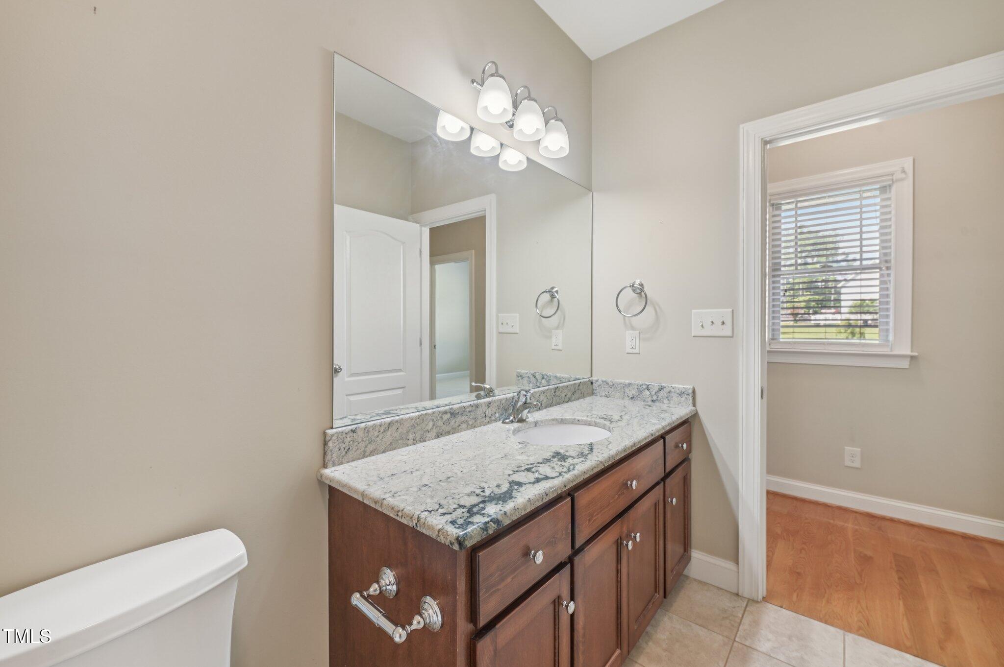 75 Crestline Drive Selma, NC 27576 - Photo 21 of 31 a bathroom with a granite countertop sink a toilet and a mirror