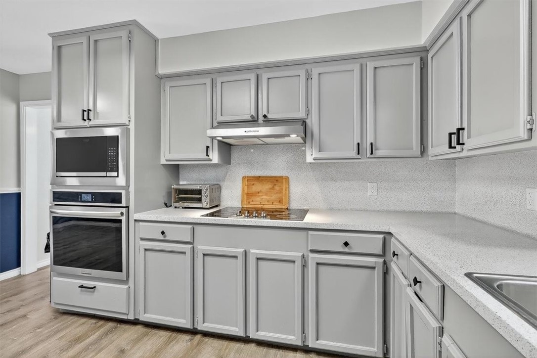 5410 Fox Run Drive Corpus Christi, TX 78413 - Photo 14 of 40 a kitchen with white cabinets and stainless steel appliances