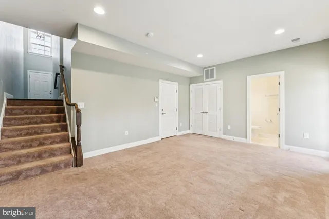 a view of an empty room with wooden floor and entryway