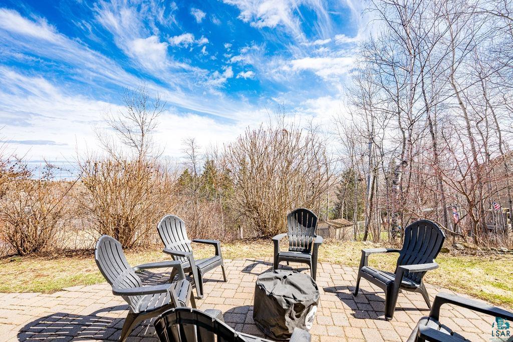 4856 Kingston Street Duluth, MN 55804 - Photo 50 of 88 Brick paver patio surrounded by natural landscaping, featuring a fire pit area
