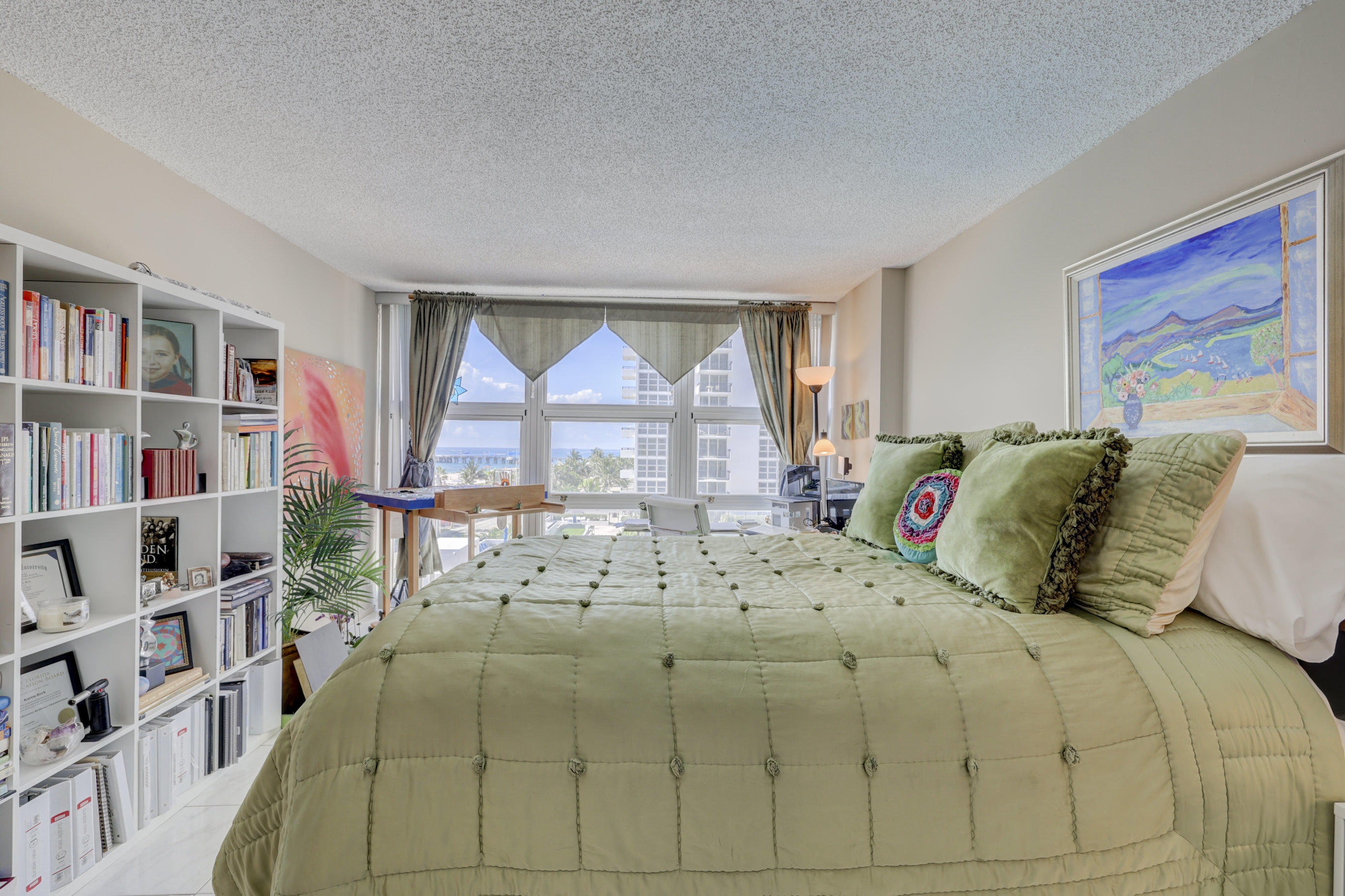 531 North Ocean Boulevard, Unit 710 Pompano Beach, FL 33062 - Photo 21 of 39 a bedroom with a bed a large window and a book shelf