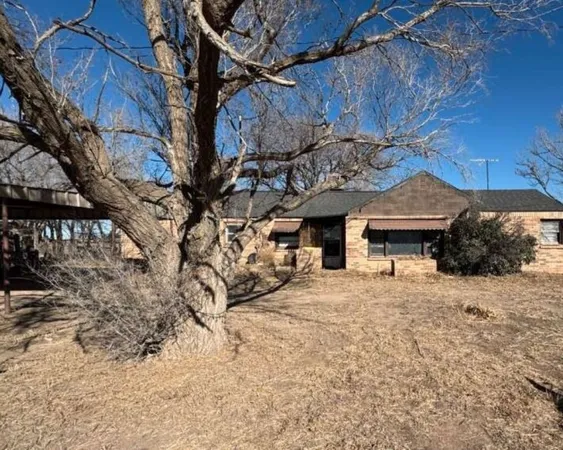 a front view of a house with a yard covered with snow