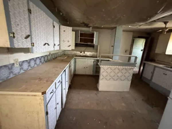 a kitchen with granite countertop a sink a counter top space stainless steel appliances and cabinets