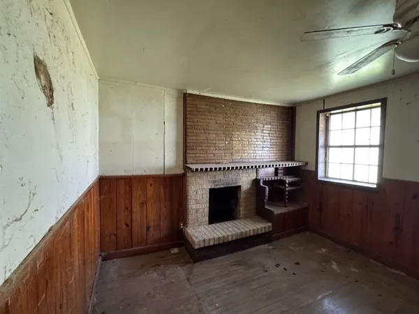 a view of an empty room with a fireplace and a window