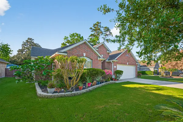 a view of a house with a big yard and potted plants in front of it