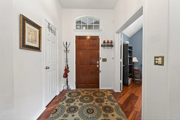 a view of a dining room with furniture a chandelier and wooden floor