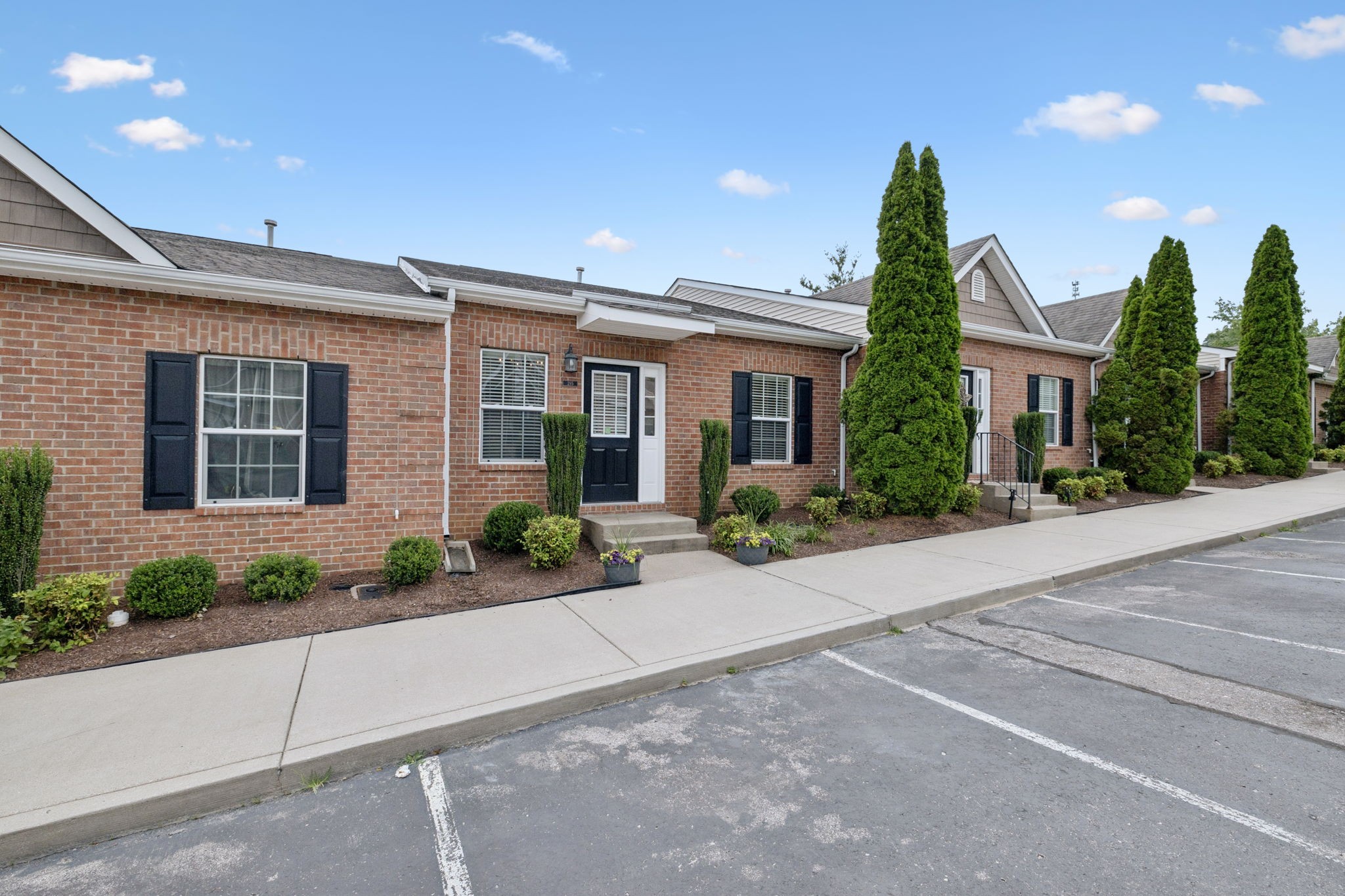 1101 Downs Boulevard, Unit 295 Franklin, TN 37064 - Photo 3 of 33 a front view of a house with a yard and potted plants