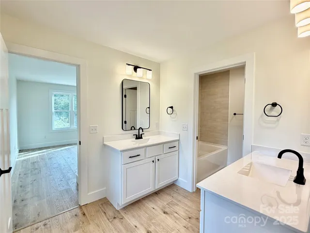 a bathroom with a tub sink and mirror