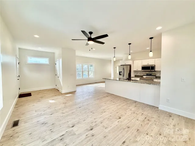 a view of a kitchen with kitchen island wooden floor and appliances