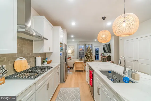 a large kitchen with stainless steel appliances granite countertop a stove and cabinets