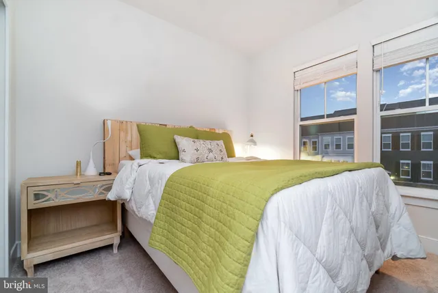 a bed sitting in a bedroom next to a large window