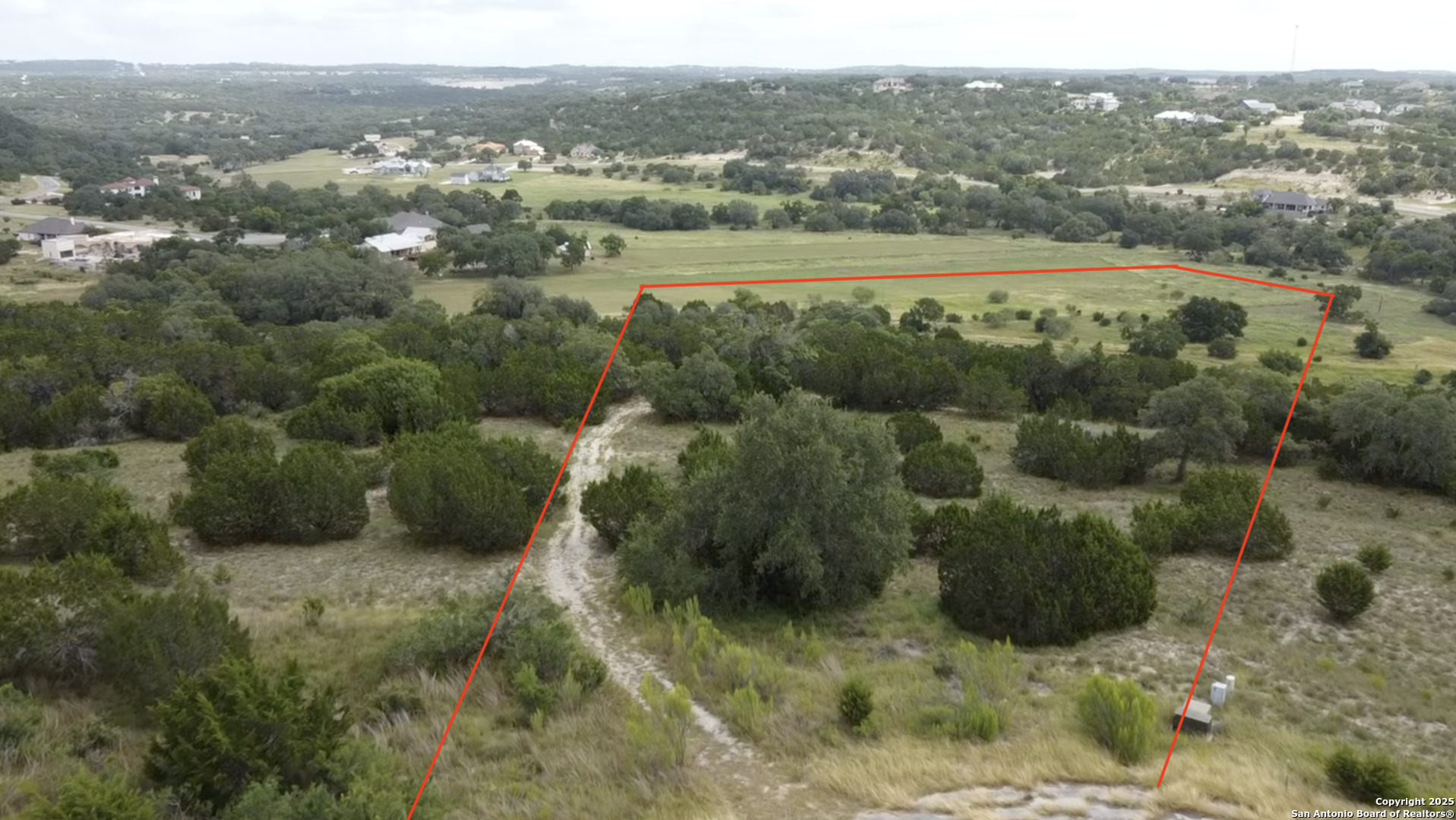 513 Gray Fox Spring Branch, TX 78070 - Photo 2 of 20 a view of a green yard with mountains in the background