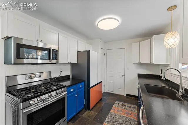a kitchen with stainless steel appliances granite countertop a stove a sink and a microwave