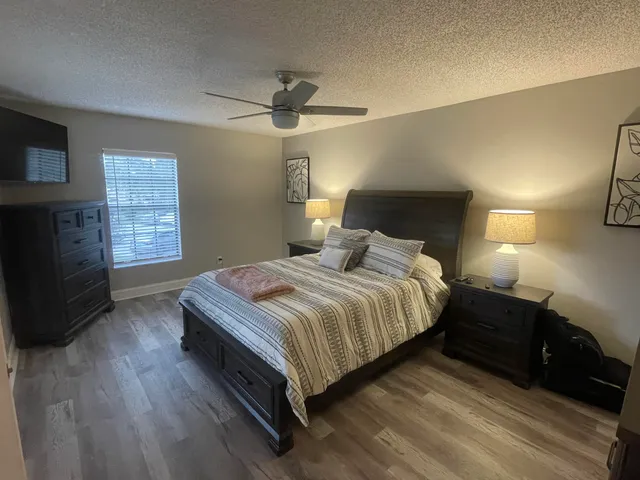a bedroom with a bed and a flat tv screen on dresser