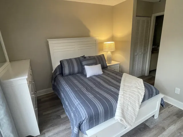 a bedroom with a bed and wooden floor