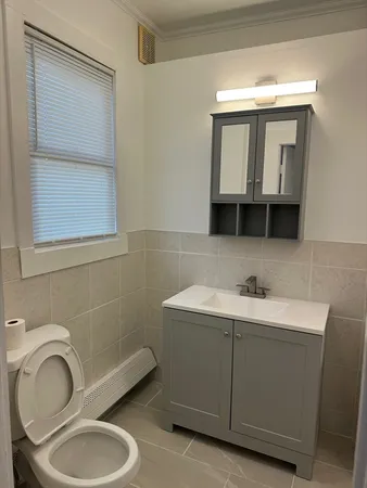 a bathroom with a toilet sink and mirror