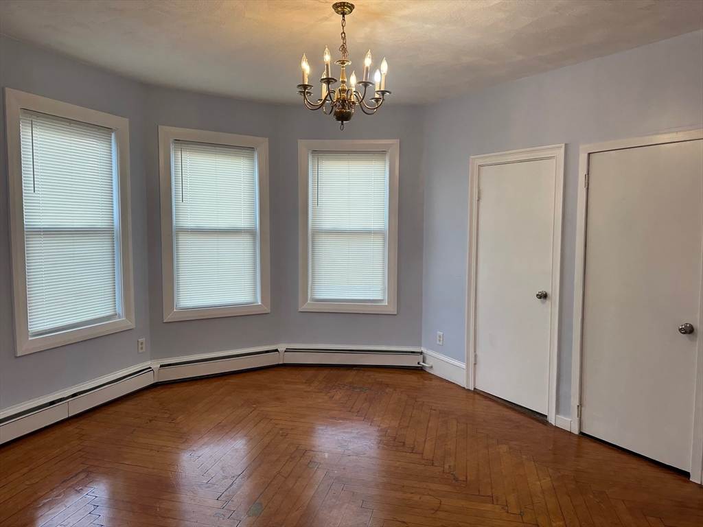 347 Summer Street, Unit 2 Lynn, MA 01905 - Photo 6 of 14 wooden floor in an empty room with a window