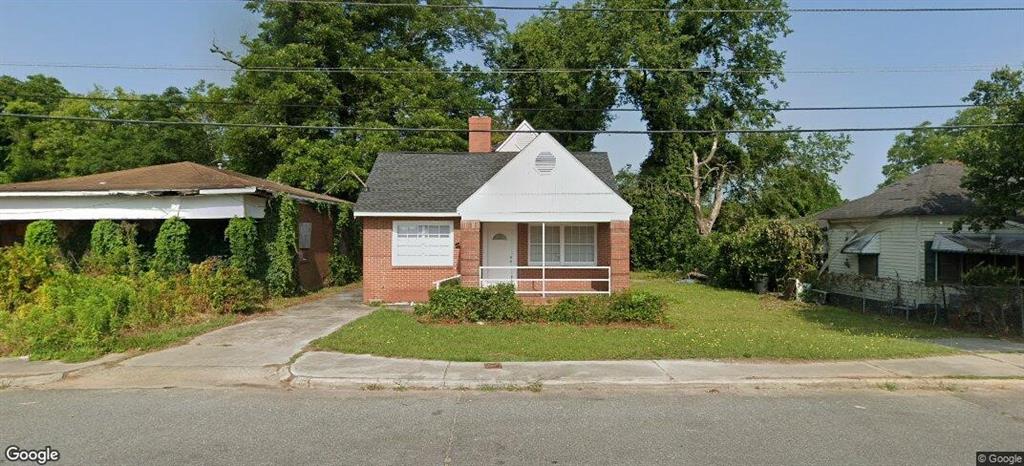 a front view of a house with a garden and trees