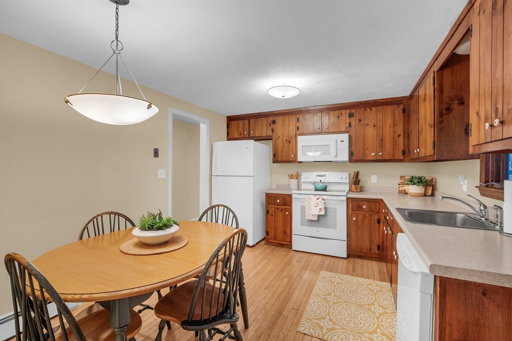 117 Waite Road Boxborough, MA 01719 - Photo 11 of 37 a kitchen with stainless steel appliances kitchen island a table chairs and a refrigerator