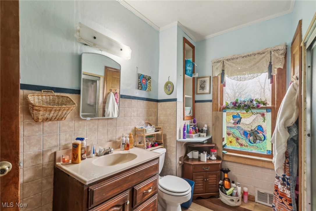 944 Bey Road Akron, OH 44312 - Photo 22 of 47 Bathroom with tile walls, visible vents, toilet, and ornamental molding