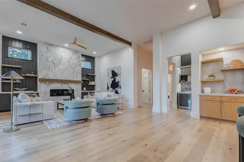 a living room with furniture a fireplace and a kitchen view
