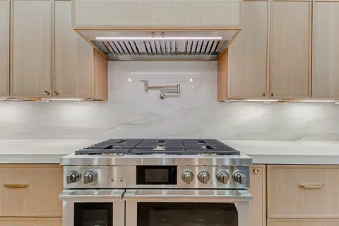 a stove top oven sitting inside of a kitchen