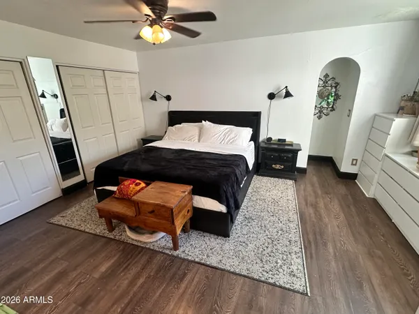 a bedroom with a bed and wooden floor