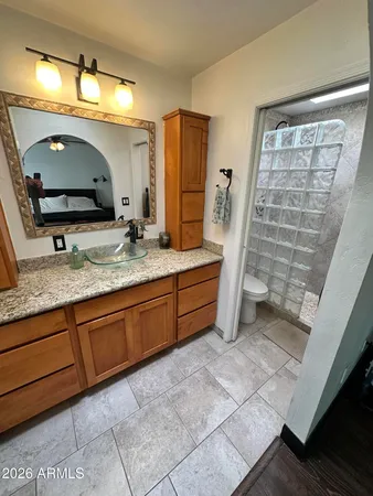 a bathroom with a granite countertop sink a mirror and a shower