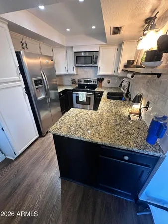 a kitchen with granite countertop stainless steel appliances and wooden cabinets