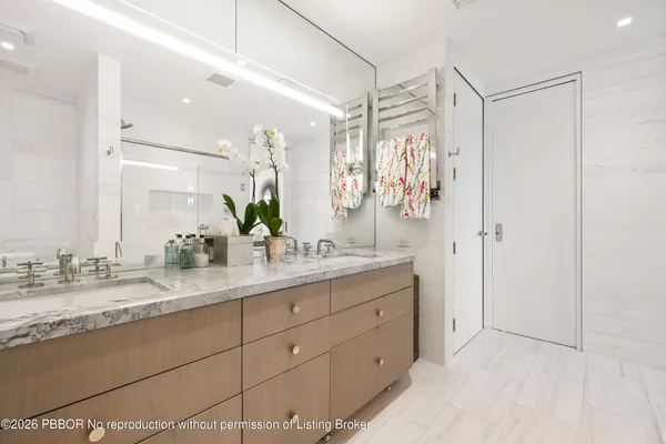 a bathroom with a double vanity sink mirror and shower