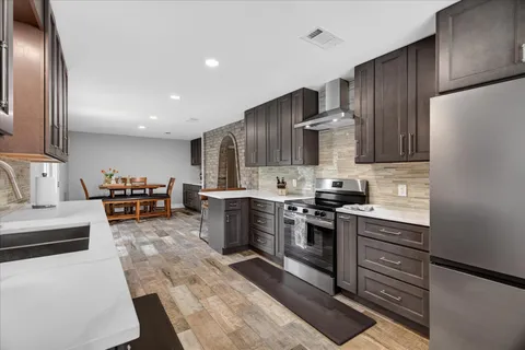 a kitchen with stainless steel appliances granite countertop a stove refrigerator and cabinets