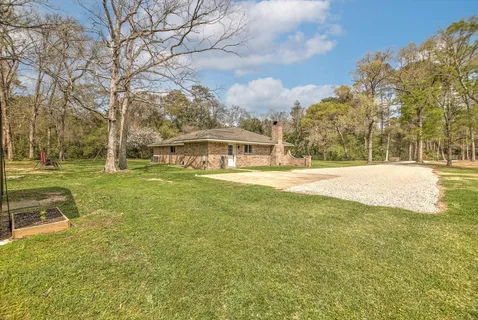 a view of yard with tree in front of it