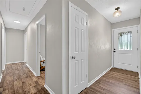 a view of a hallway with wooden floor and staircase