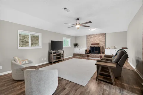 a living room with furniture a flat screen tv and a fireplace