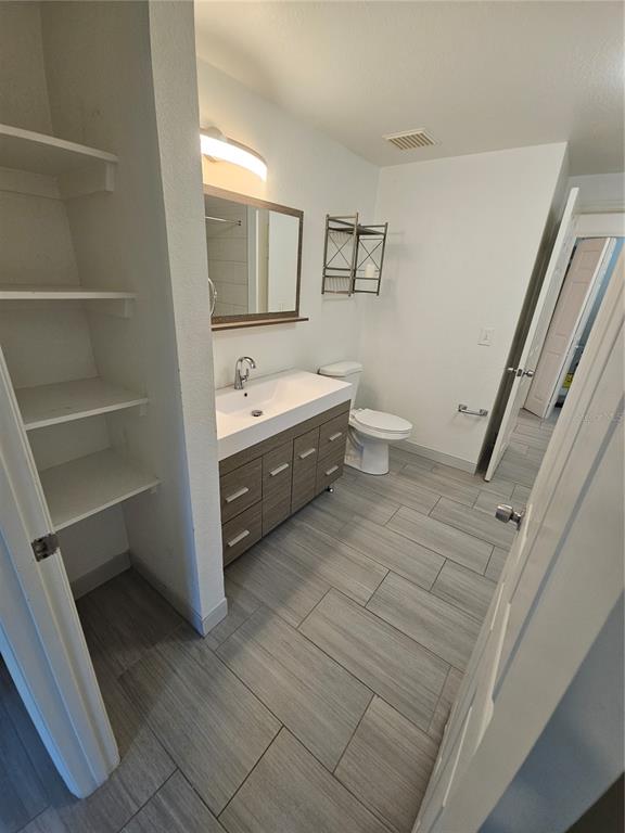 3446 Soho Street, Unit 108 Orlando, FL 32835 - Photo 11 of 39 a bathroom with a double vanity sink toilet and mirror