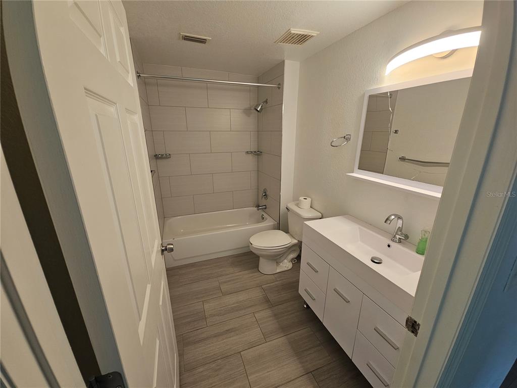 3446 Soho Street, Unit 108 Orlando, FL 32835 - Photo 14 of 39 a bathroom with a double vanity sink toilet and shower