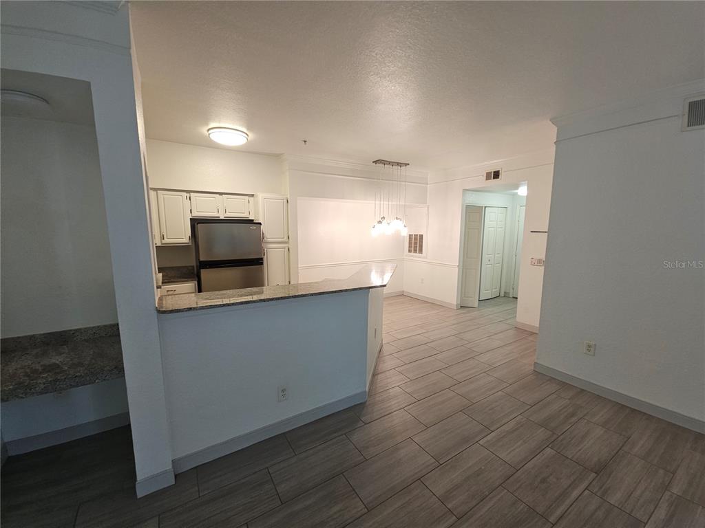 3446 Soho Street, Unit 108 Orlando, FL 32835 - Photo 9 of 39 a kitchen with stainless steel appliances a refrigerator and microwave