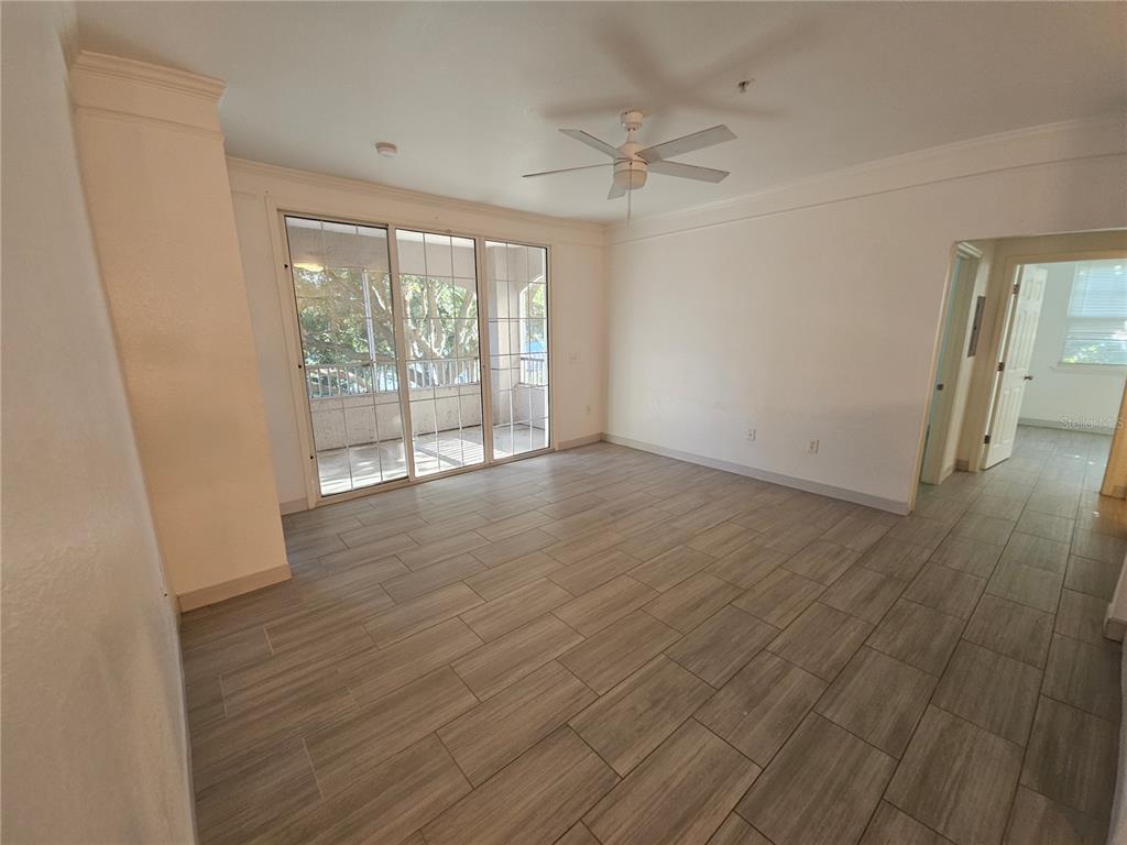 3446 Soho Street, Unit 108 Orlando, FL 32835 - Photo 10 of 39 a view of an empty room with wooden floor and a window