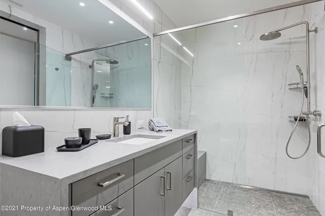 a bathroom with a double vanity sink mirror and shower
