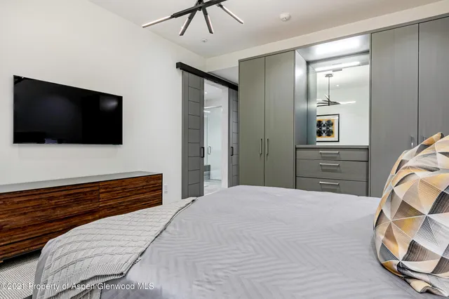 a bedroom with a bed and a flat screen tv