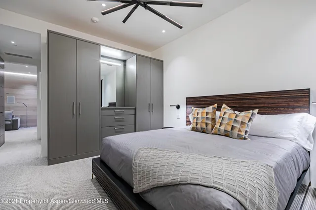 a bedroom with a large bed and a chandelier