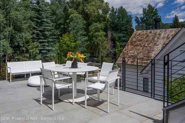 a view of a patio with table and chairs with wooden floor and fence