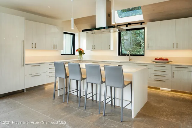 a kitchen with a stove a sink and white cabinets