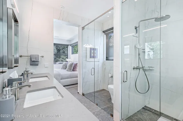 a spacious bathroom with a glass shower door and a mirror